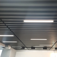 Кубообразный реечный потолок черного цвета с линейными LED светильниками из профиля