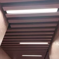 Кубообразный реечный потолок черного цвета с встраиваемыми линейными LED светильниками из профиля